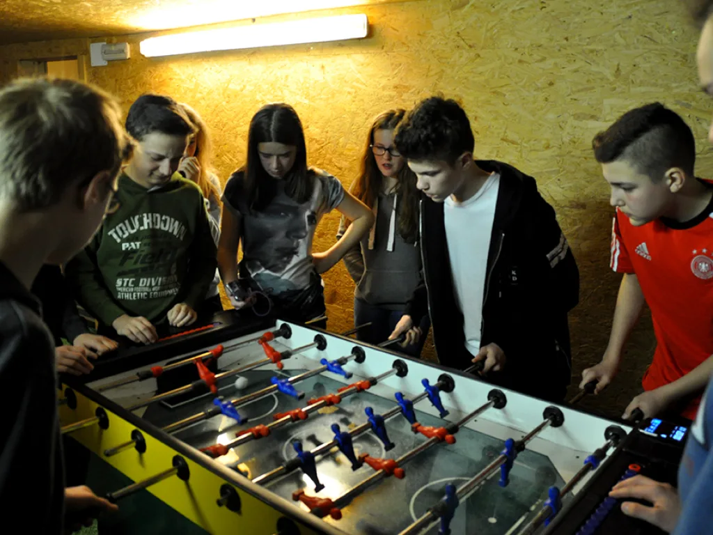 Jugendliche spielen im Aufenthaltsraum Tischfußball.